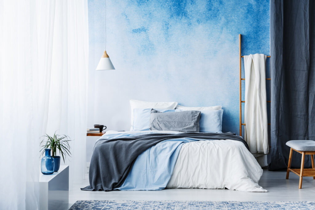 Grey and blue bedding on bed in spacious bedroom interior with ladder and plant Interior Decor Painting Ideas: Ombre Interior Wall